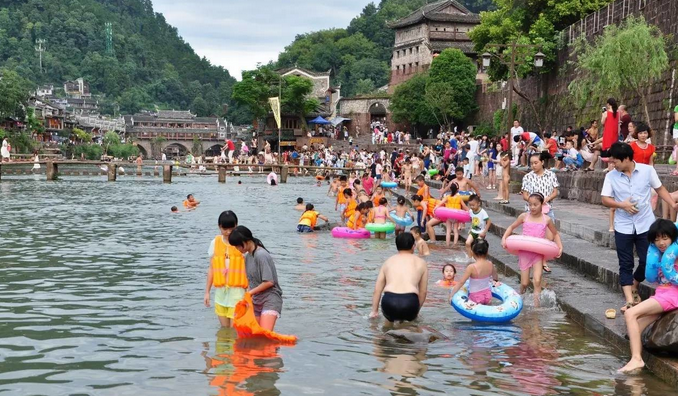 local residents and tourists enjoying the cool water on the banks of the minjiang river_4e63c8